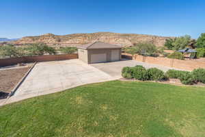 Exterior space featuring a front yard, a mountain view, a garage, and an outdoor structure