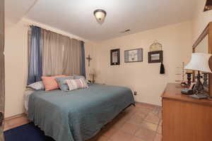 Tiled bedroom with a textured ceiling