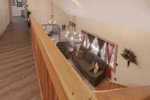 Stairway featuring an inviting chandelier, hardwood / wood-style flooring, and high vaulted ceiling