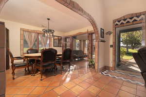 Dining space featuring a notable chandelier, a wealth of natural light, and light tile patterned floors