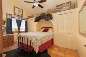 Tiled bedroom featuring multiple closets and ceiling fan