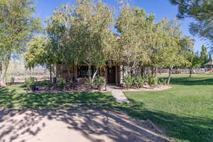 View of property hidden behind natural elements with a front yard