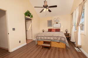 Bedroom with ceiling fan, vaulted ceiling, and dark hardwood / wood-style flooring