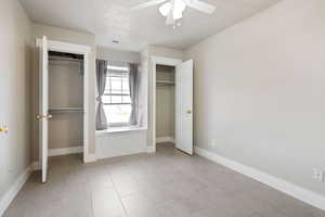 Unfurnished bedroom with ceiling fan and light tile patterned floors