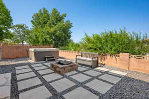 View of patio featuring an outdoor fire pit and a hot tub