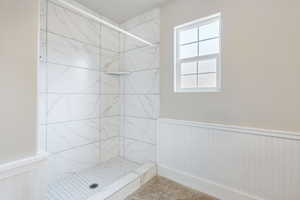 Bathroom with tile patterned flooring and tiled shower