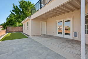 View of patio with french doors and a balcony