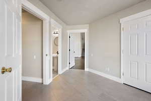 Interior space with ensuite bathroom, light wood-type flooring, and a textured ceiling