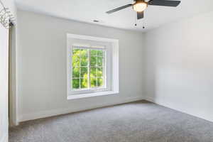 Carpeted empty room with ceiling fan