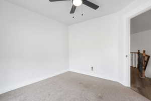 Unfurnished room with ceiling fan and carpet