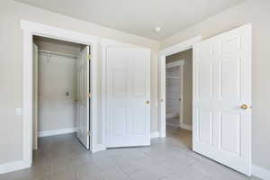 Unfurnished bedroom with a closet and light tile patterned floors