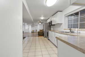 Kitchen featuring appliances with stainless steel finishes, light wood-type flooring, white cabinetry, and sink