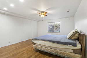 Bedroom with ceiling fan and hardwood / wood-style flooring