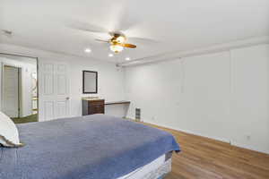 Bedroom with light hardwood / wood-style flooring, ceiling fan, and sink