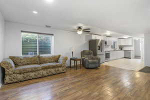 Living room featuring ceiling fan, light hardwood / wood-style flooring, and sink