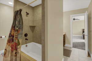 Upstairs South Bathroom with tile patterned floors, shower / bath combo, vanity, and ceiling fan