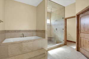 Master Bathroom with tile patterned flooring and plus walk in shower