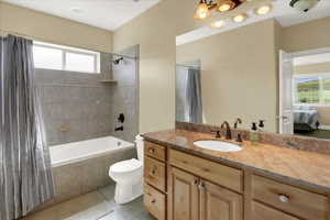 Basement North Full bathroom featuring shower / tub combo, tile patterned floors, vanity, and toilet