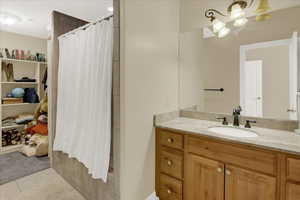 Upstairs North Bathroom with tile patterned floors, a shower with shower curtain, and vanity