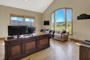 Primary office featuring lofted ceiling and light hardwood / wood-style floors