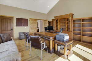 Primary Office featuring light hardwood / wood-style floors and high vaulted ceiling