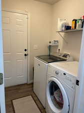 Laundry area featuring washing machine and clothes dryer and dark hardwood / wood-style floors