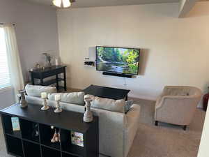 Living room featuring ceiling fan and carpet