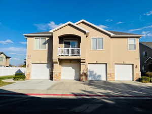 View of front of house with a garage and a balcony