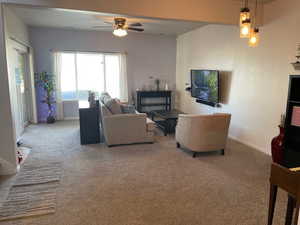 Living room featuring ceiling fan and carpet flooring