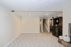 Basement with a textured ceiling and light carpet