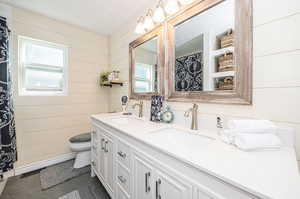 Owner's Bathroom featuring a healthy amount of sunlight, vanity, toilet, and tile patterned floors