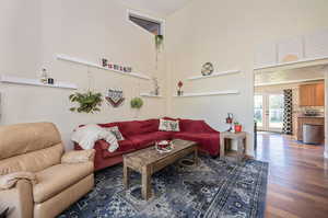 Living room with hardwood flooring, vaulted ceiling,