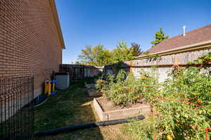 View of yard featuring central air condition unit, and raised garden beds