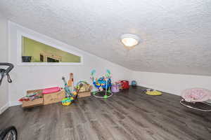 Playroom with a textured ceiling and hardwood / wood-style flooring