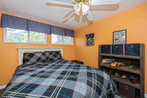 Bedroom with ceiling fan and a textured ceiling