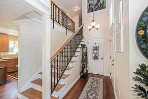 Foyer featuring a textured ceiling,hardwood flooring, and a chandelier