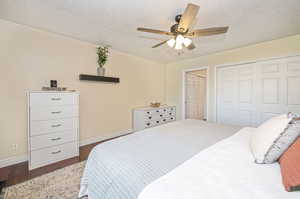 Owner's Suite with a closet, wood-type flooring, ceiling fan, and a textured ceiling