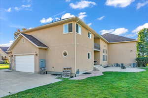 Back of property featuring a lawn and central AC unit