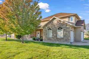 View of property featuring a front lawn and a garage