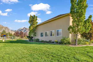 View of side of home with a yard and a mountain view