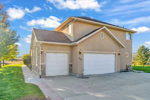 View of front facade featuring a garage and a front lawn