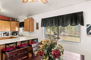 Kitchen featuring ceiling fan, lofted ceiling, sink, and tile patterned floors