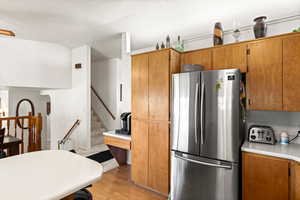 Kitchen featuring stainless steel refrigerator and light hardwood / wood-style flooring