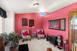 Sitting room with lofted ceiling and carpet flooring