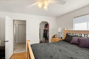 Bedroom featuring hardwood / wood-style floors, ceiling fan, a closet, and a walk in closet