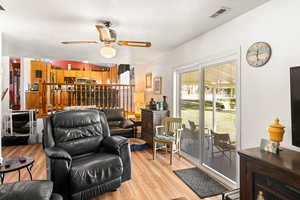 Living room featuring light hardwood / wood-style flooring, a textured ceiling, and ceiling fan