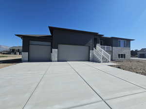 View of front of home with a mountain view and a garage