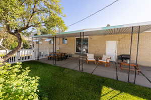 Rear view of house featuring a yard and a patio area