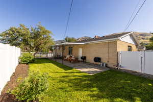 Back of property with a yard and a patio area