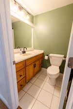 Bathroom featuring toilet, tile patterned flooring, and vanity